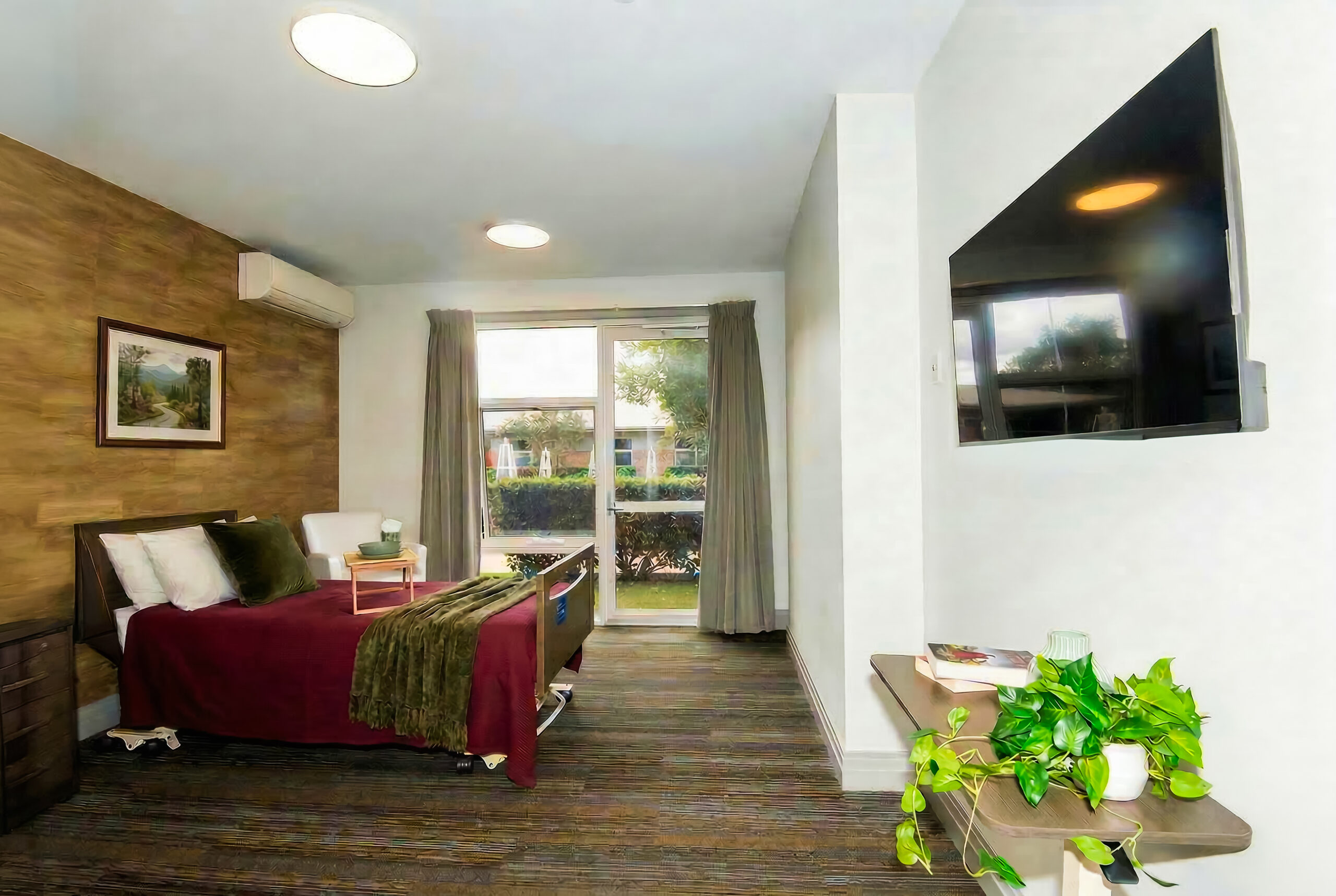 A Premium Room at Burpengary Manor Aged Care with private garden access, spacious layout, and a wall-mounted Smart TV.